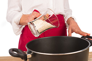 vertiendo arroz en un cazo para cocerlo